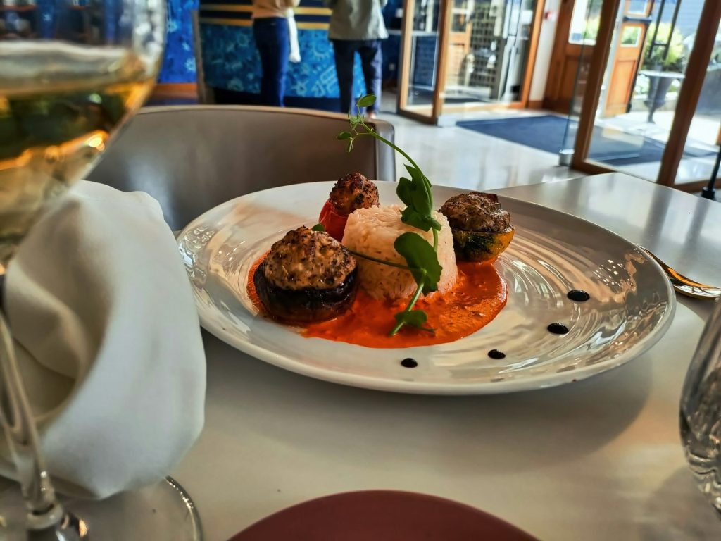 Ein Teller mit Essen und ein Glas Wein auf einem Tisch